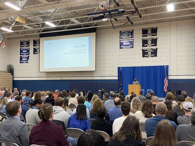 Penn State Mont Alto Chancellor stands at the podium while a crowd sits in the audience watching